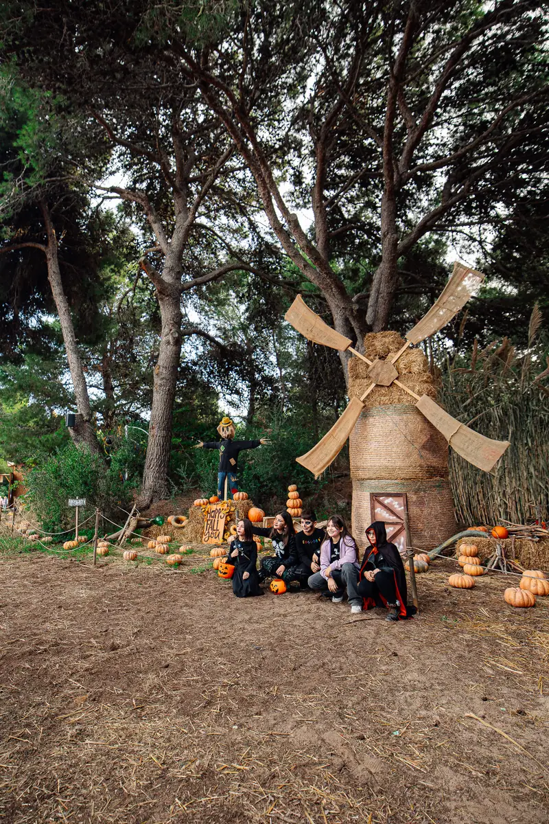 Ragazzi in maschera accanto al mulino di paglia e alle zucche — Parco d’Autunno al Raffo Parco Gondar di Gallipoli