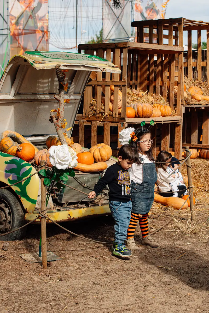 Bambini accanto a un’auto decorata con zucche e fiori — Parco d’Autunno al Raffo Parco Gondar di Gallipoli
