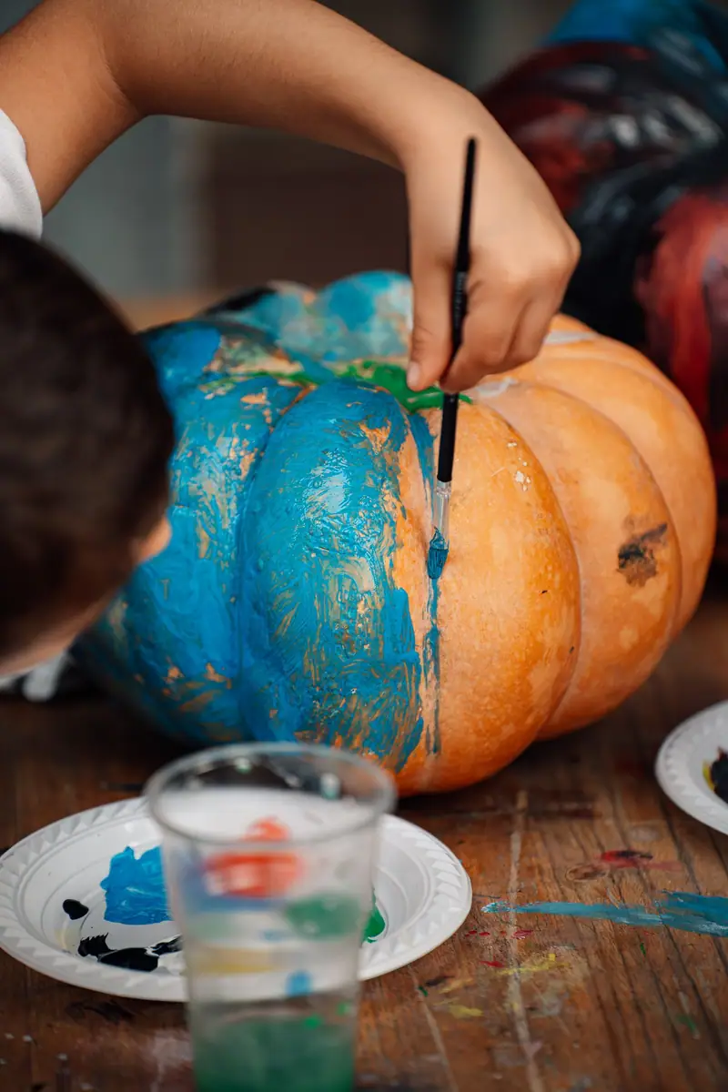 Mano dipinge zucca blu, sfocata — Parco d’Autunno al Raffo Parco Gondar di Gallipoli