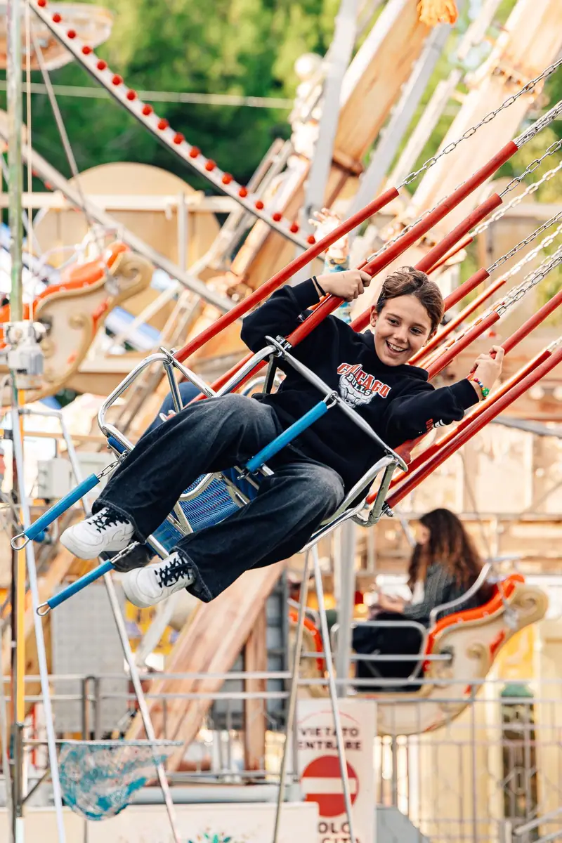 Ragazzo sorridente sulla giostra a catene — Parco d’Autunno al Raffo Parco Gondar di Gallipoli