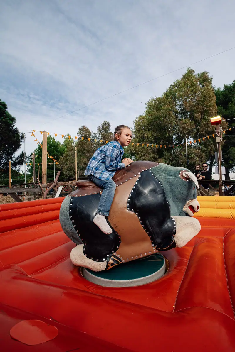 Bambino sul toro meccanico, all’aperto — Parco d’Autunno al Raffo Parco Gondar di Gallipoli