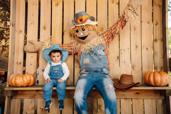 Zuccotto, la mascotte del parco, con le braccia alzate accanto a un bambino sulla panca delle foto — Parco d’Autunno 2026 al Raffo Parco Gondar di Gallipoli