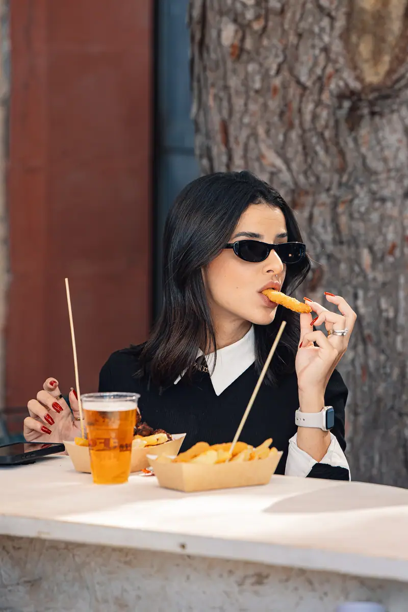 Ragazza mangia patatine con birra