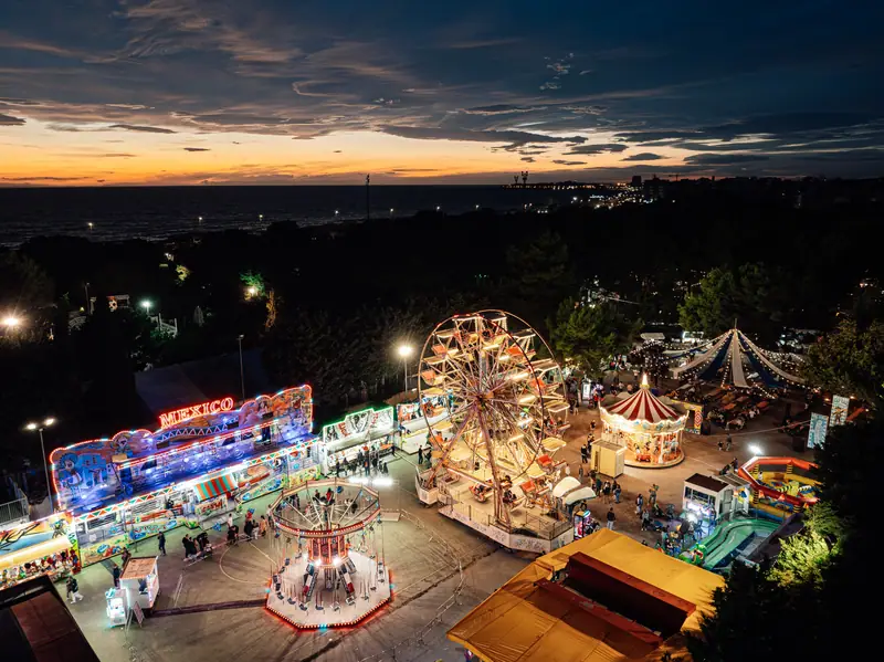 Vista dall’alto: luna park acceso al tramonto
