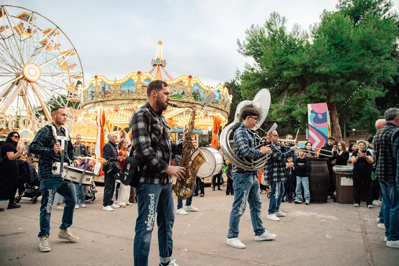 Banda in marcia, giostra e ruota panoramica