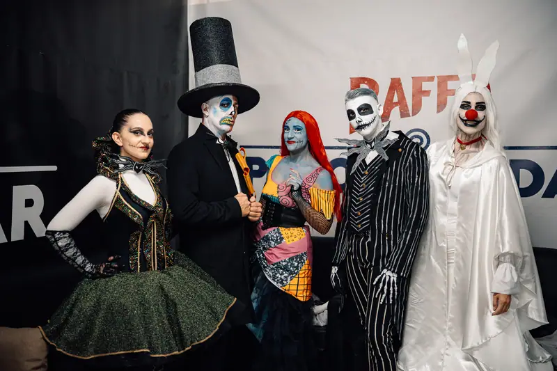 Personaggi in costume davanti backdrop Raffo